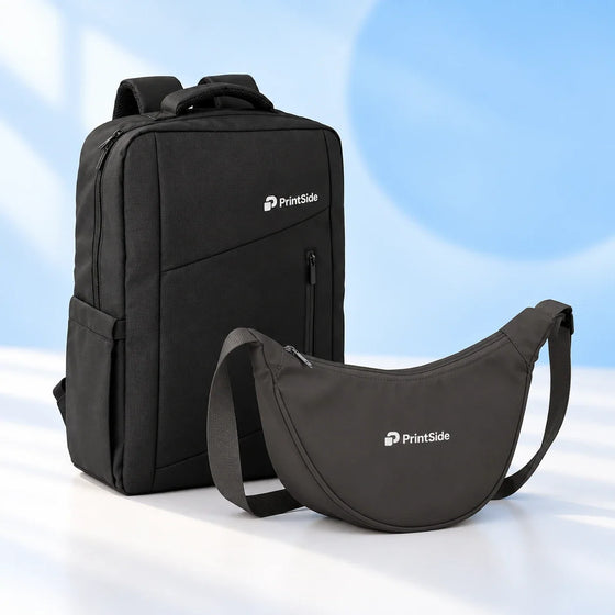 Black laptop backpack and charcoal crossbody bag with PrintSide logos.