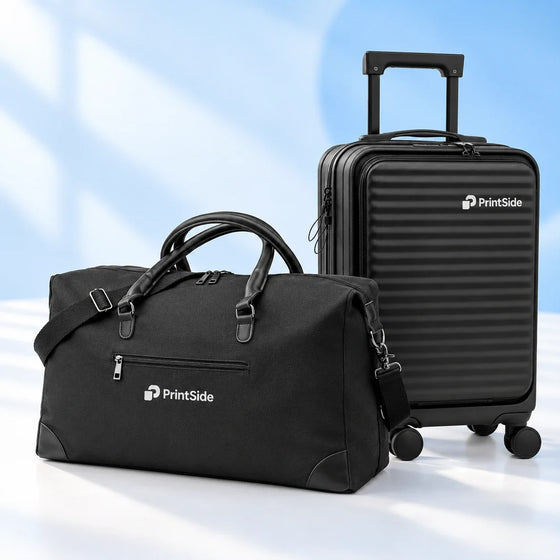 Black travel bag and wheeled suitcase with PrintSide logos.