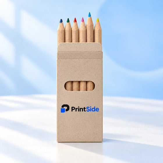 Färgpennor av naturträ i ett kraftpappersfodral med PrintSide-logotyp.