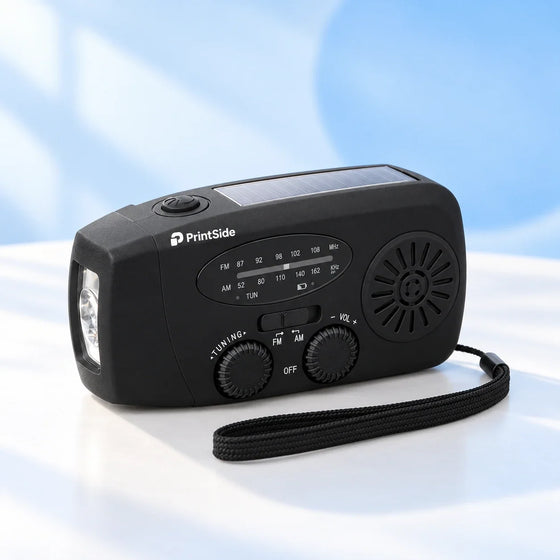 Black AM/FM radio with a solar panel, side flashlight, wrist strap and white PrintSide logo.