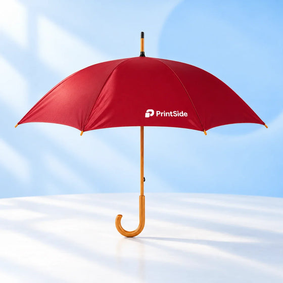 Open deep red umbrella with a wooden shaft, curved handle and PrintSide logo.
