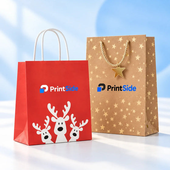Red reindeer gift bag and kraft gift bag with gold stars and PrintSide logos.