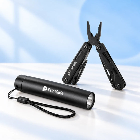 Black multitool pliers and flashlight with PrintSide logos.