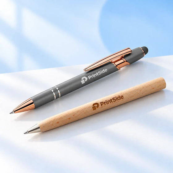 Grey metal pen and natural wooden pen with PrintSide logos.