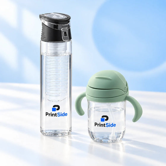 Clear sports water bottle with a black lid and a child’s cup with green handles, both with PrintSide logos.