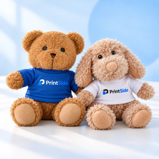 Brown teddy bear and fluffy beige plush dog wearing PrintSide shirts.