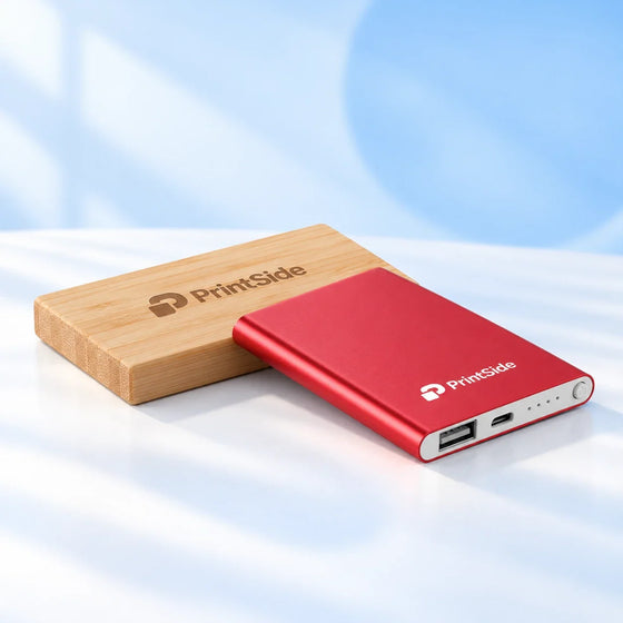 Powerbank i bambu och röd metall med PrintSide-logotyper.