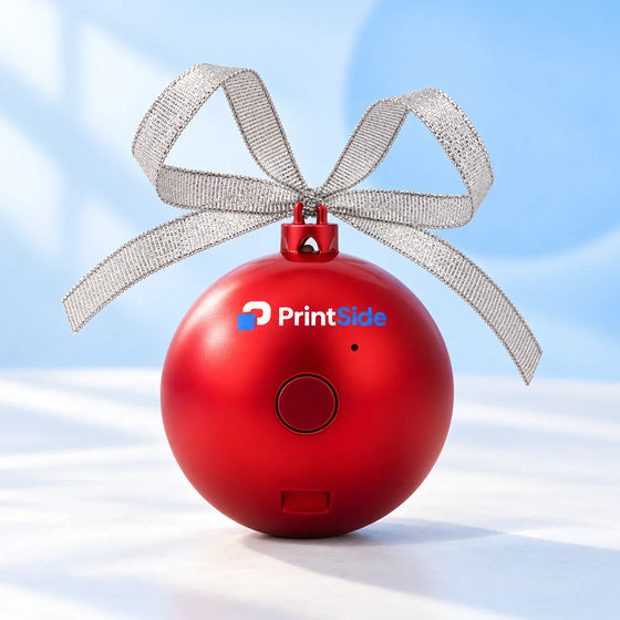 Red Christmas bauble speaker with a silver ribbon bow and PrintSide logo.