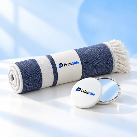 Rolled blue-and-white towel and white pocket mirror with PrintSide logos.