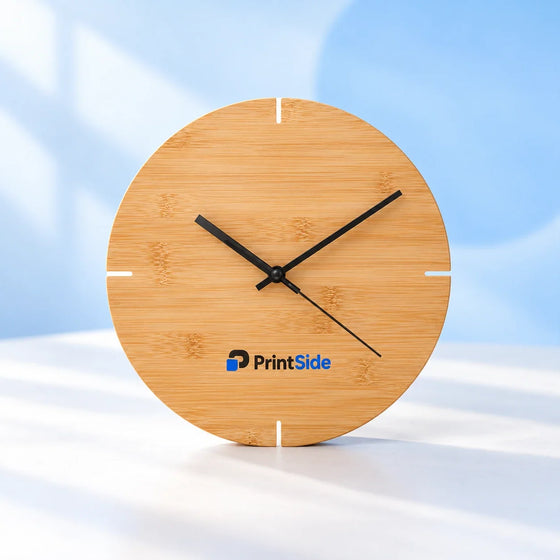 Round bamboo clock with black hands and a PrintSide logo.