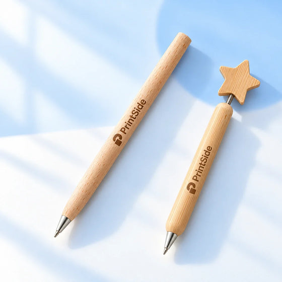 Natural wooden ballpoint pens, one with a star topper, with PrintSide engraving.